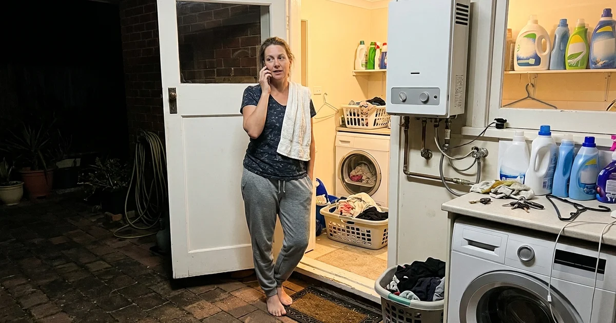 Homeowner on the phone at night near a hot water unit