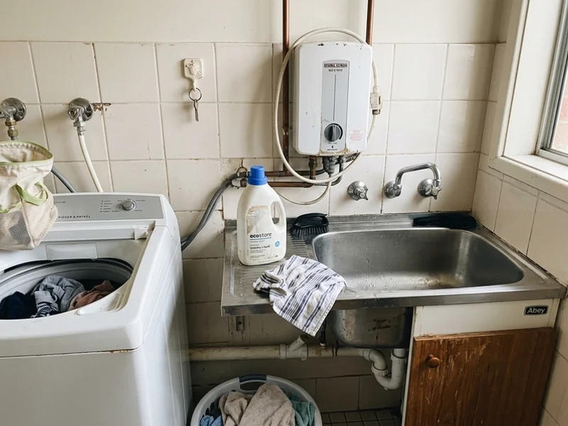 Compact instantaneous electric unit mounted above a laundry trough